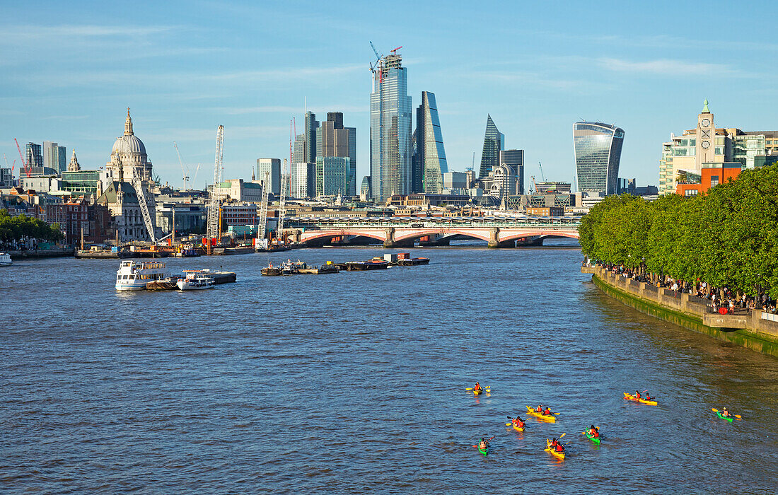 Boats on the River Thames with skyscrapers and landmarks; London, England