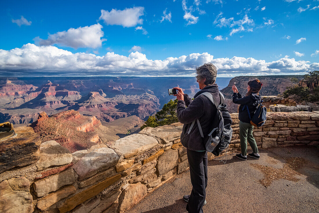 Tourists taking photos of the views of the Grand Canyon from the Rim Trail near the Village, Grand Canyon National Park; Arizona, United States of America