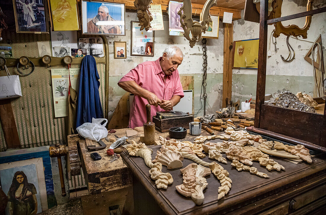 Holzschnitzer bei der Arbeit in seiner Werkstatt; Venedig, Italien