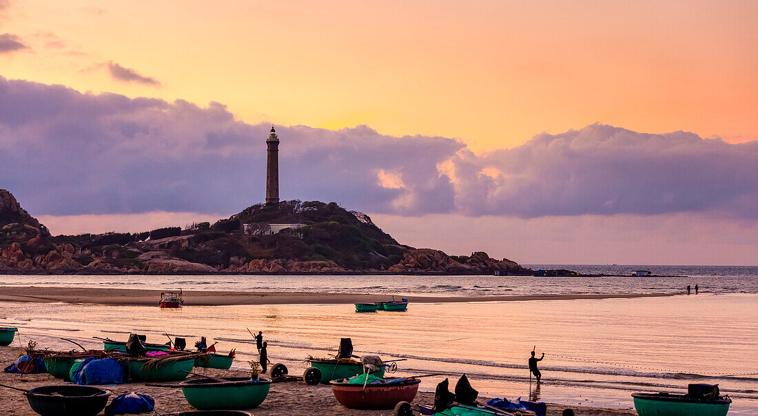 Ke Ga  Cape at sunrise with fishermen on the beach and a lighthouse on the coast; Ke Ga, Binh Thuan Province, Vietnam