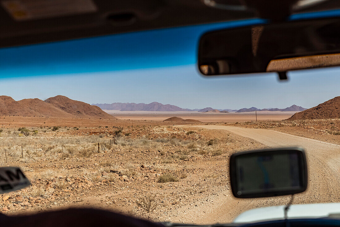 Fahren auf einer langen Trockenstraße, Namib-Wüste; Namibia