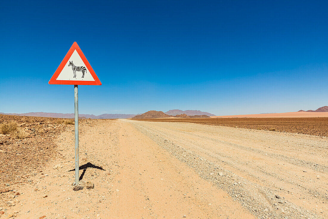 Attention wild animals sign on a long dry road, Namib Desert, Namib-Naukluft National Park; Namibia