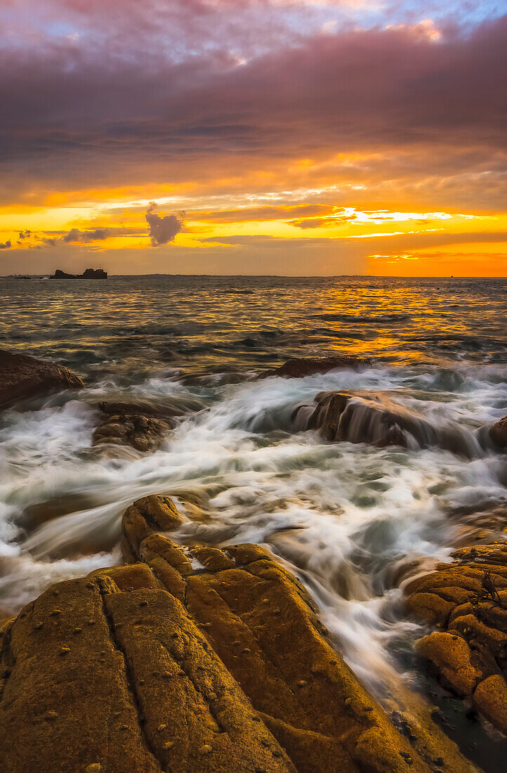 Sunset over the rocks along the French Atlantic shoreline, long exposure; Perharidi, Brest, France