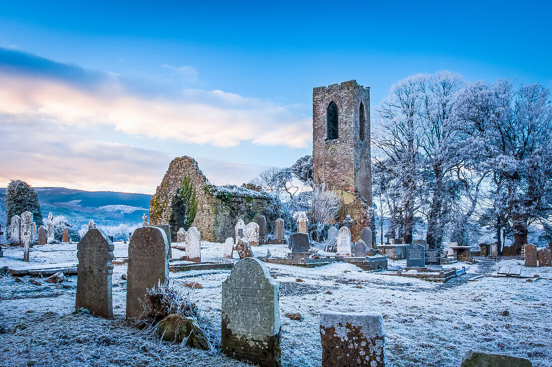 Shanrahan Church, eine alte Kirchenruine und ein mit Schnee bedeckter Friedhof bei Sonnenaufgang; Adrfinnan, County Tipperary, Irland