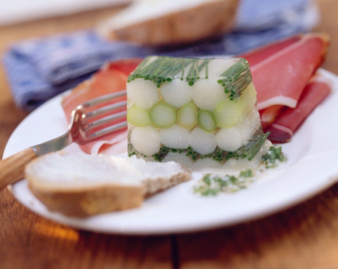 White & green asparagus jelly with ham on a plate