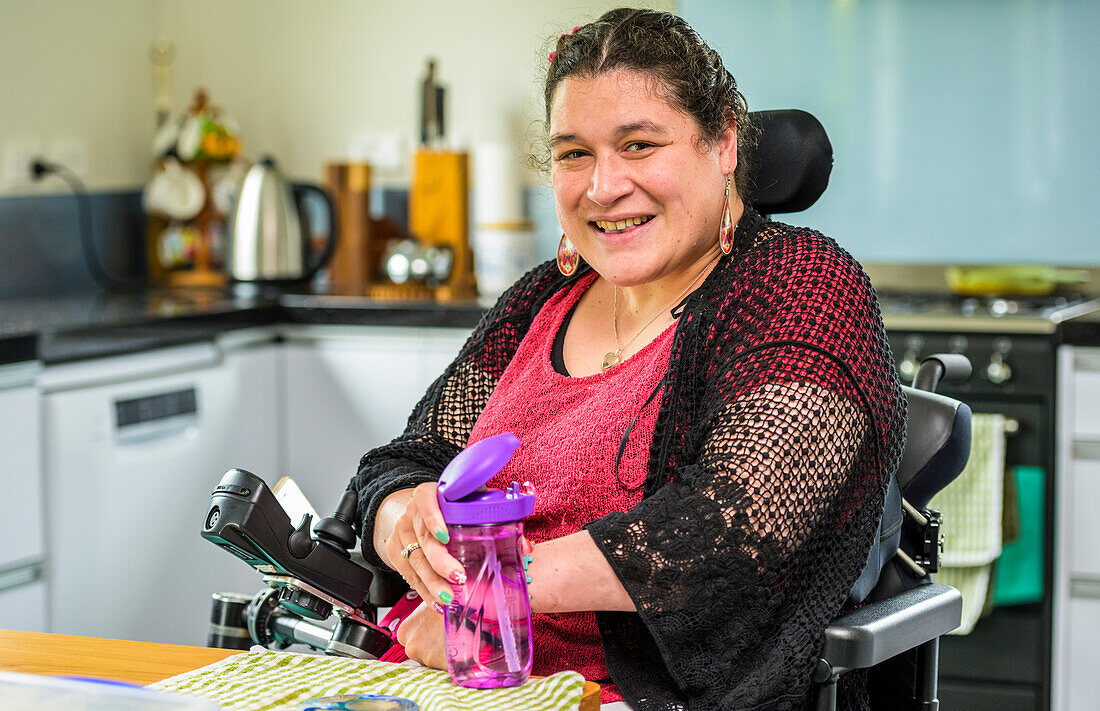 Maori-Frau mit Cerebralparese im Rollstuhl; Wellington, Neuseeland