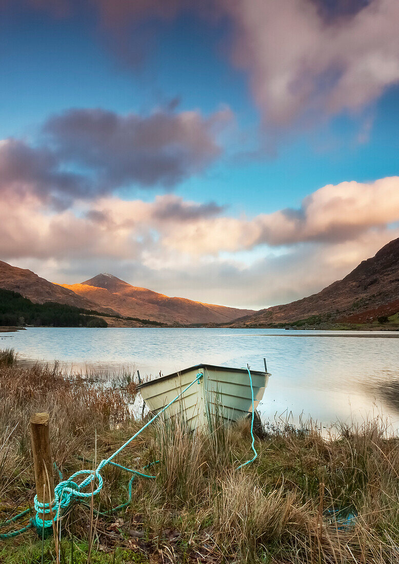 Ein Boot an einem Seeufer mit einem Tal und Bergen im Hintergrund; Black Valley, County Kerry, Irland