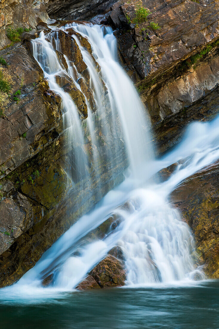 Waterfalls on angled rocky cliff, Waterton Lakes National Park; Waterton, Alberta, Canada