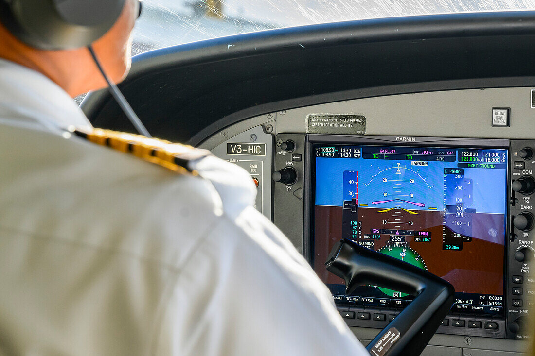 Pilot im Cockpit eines Flugzeugs; Belize