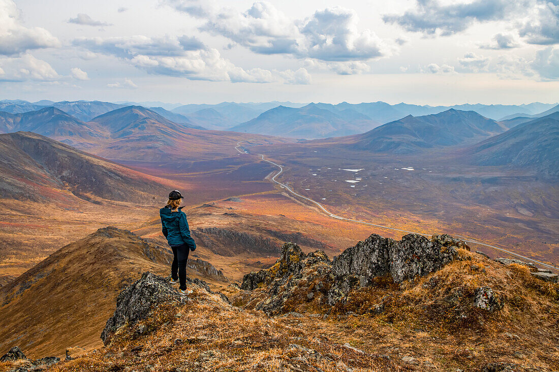 Woman exploring the mountains along the Dempster Highway during autumn in the autumn; Yukon, Canada