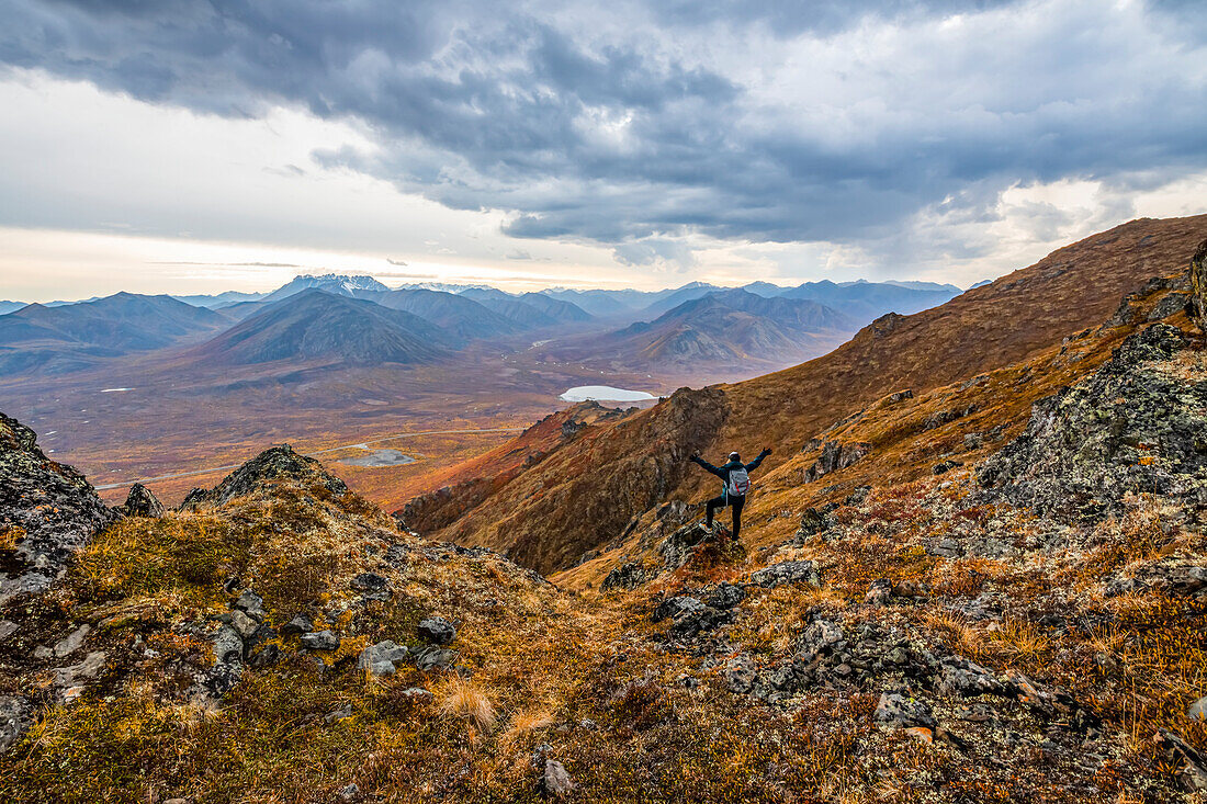 Frau erkundet die Berge entlang des Dempster Highway im Herbst im Herbst; Yukon, Kanada