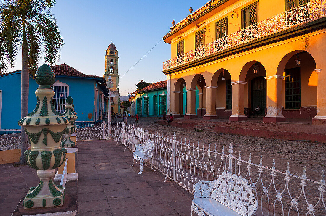 White metal chairs and fence in front of Museo Romantico and Tower of the San Francisco Convent in background, Trinidad, Cuba, West Indies, Caribbean