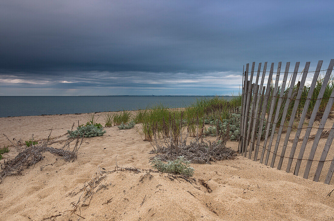 Holzzaun am Strand mit dunklen Wolken, Cape Cod, Massachusetts, USA