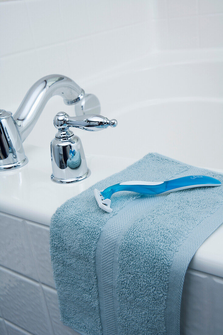 Razor and Wash Cloth on edge of Tub