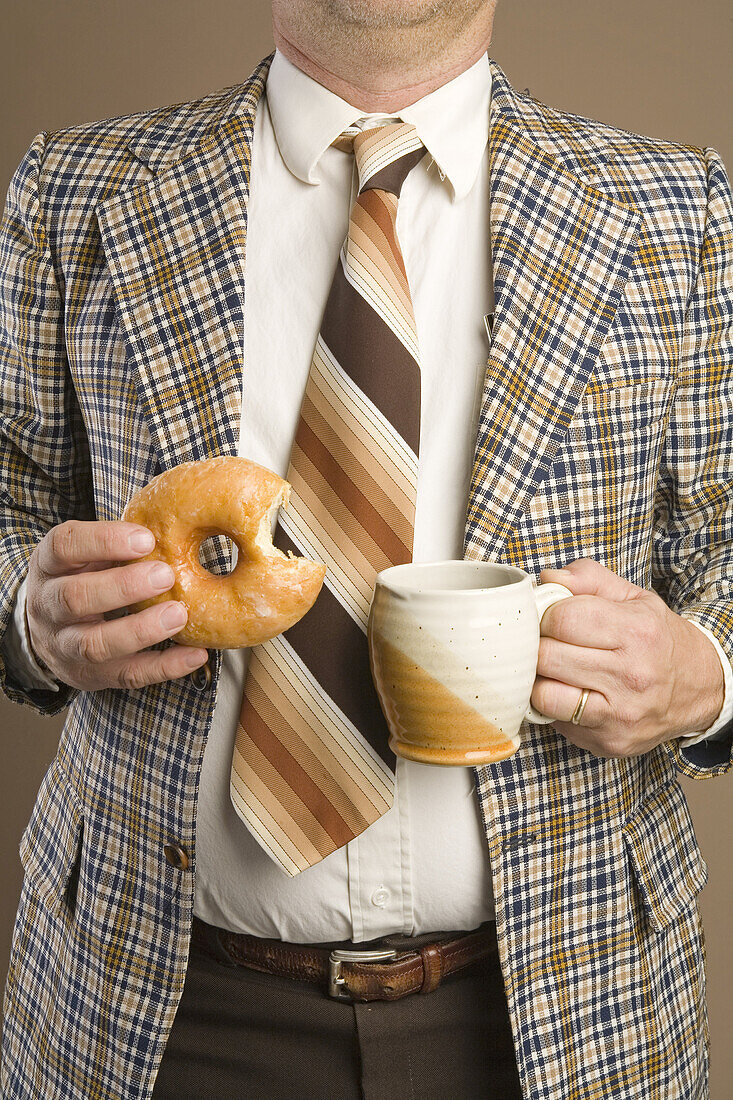 Retro-Geschäftsmann, der einen Doughnut isst und eine Tasse Kaffee trinkt