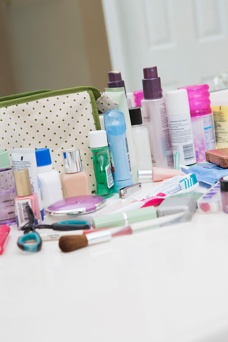 Damen-Toiletten- und Kosmetik-Reisetasche auf dem Badezimmertisch, mit Zahnbürste, Lotion, Make-up und anderen Schönheitsprodukten, USA