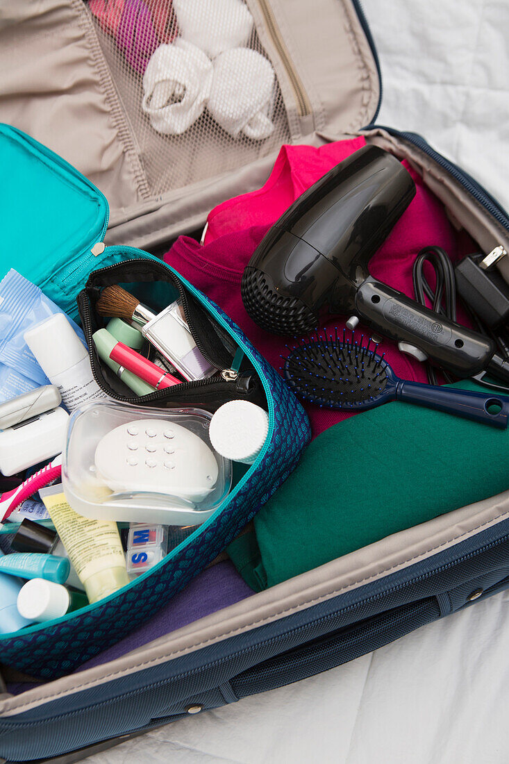 Damen-Toiletten-Reisetasche im gepackten Koffer