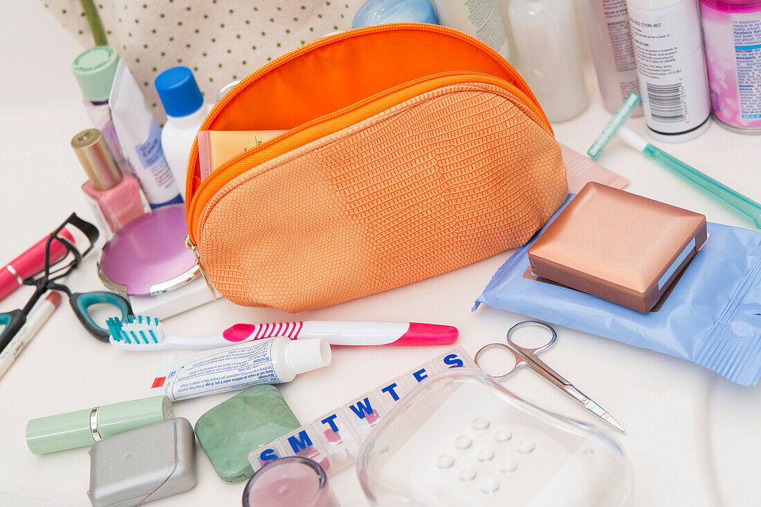 Damen-Toiletten-Reisetasche auf dem Badezimmertresen, gefüllt mit Körperpflegeprodukten