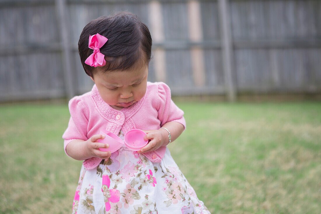 Toddler Girl Frowning as she Opens an Empty Easter Egg