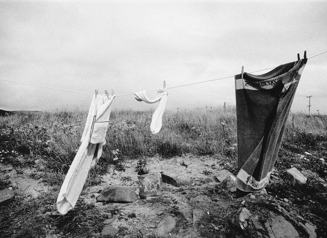 Wäsche von der Wäscheleine hängend In einem Feld mit hohem Gras und Felsen