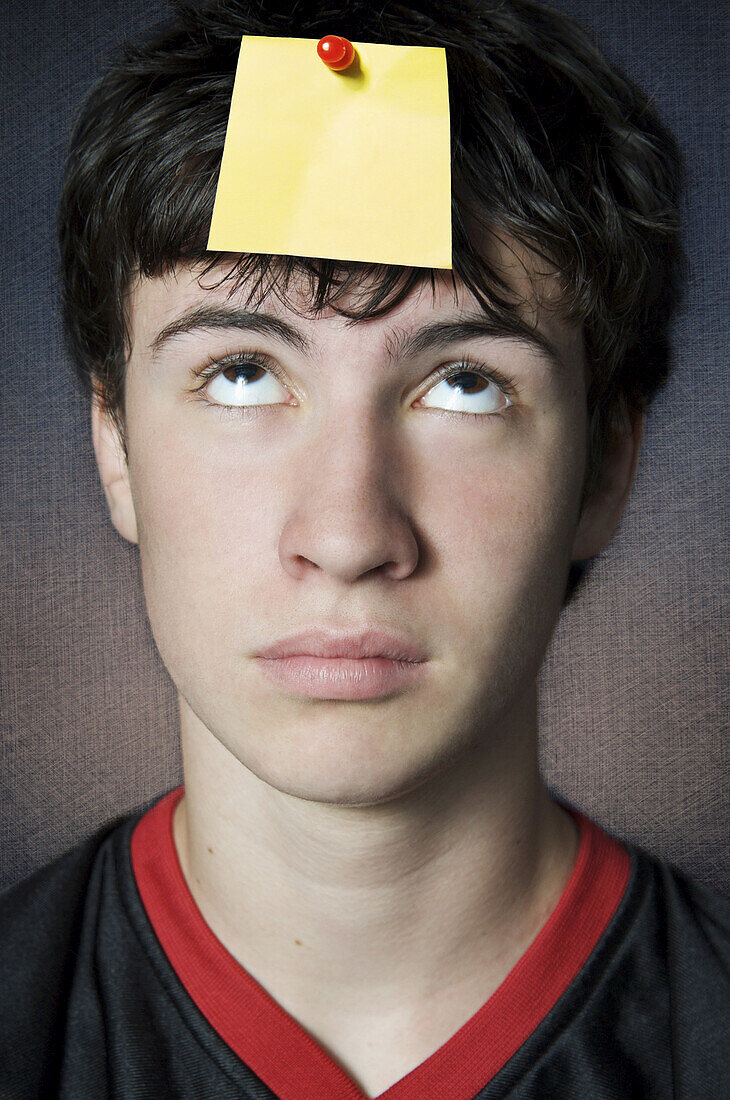 Teenager Looking at Blank Note Pinned to his Head