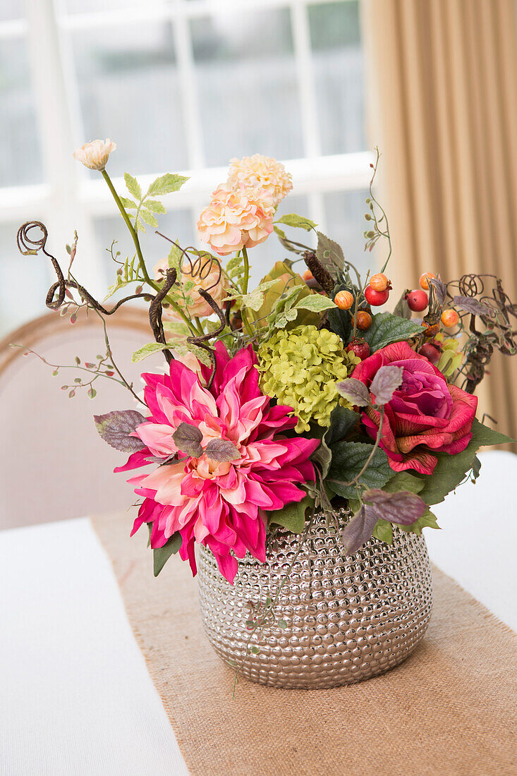 Blumenschmuck auf dem Tisch mit Läufer aus Sackleinen