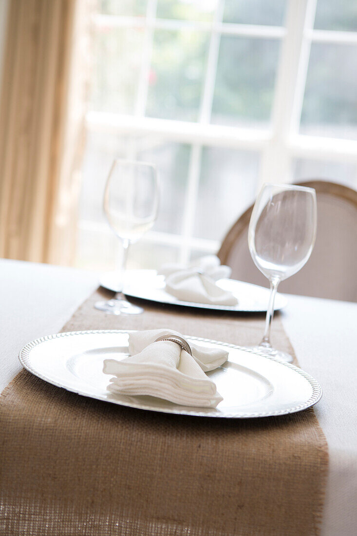 Simple and elegant place setting for two with plate charger and napkin