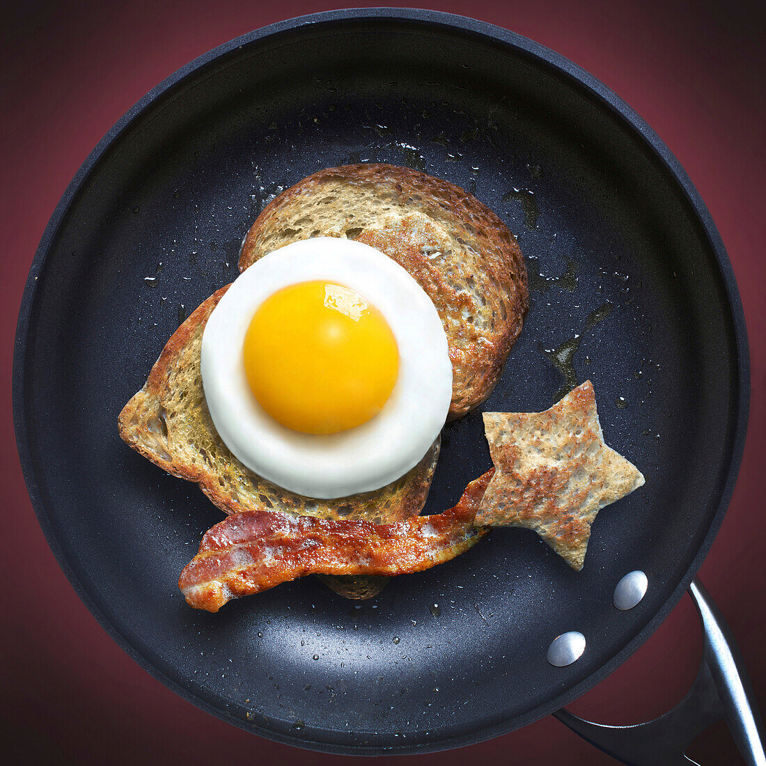 Blick auf Bratpfanne mit Speck, Ei und Toast