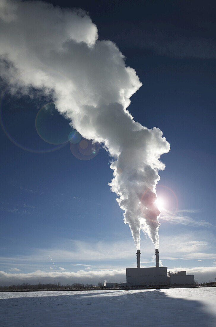 Industrial smoke stacks with steam billowing into blue sky, Toronto, Ontario, Canada