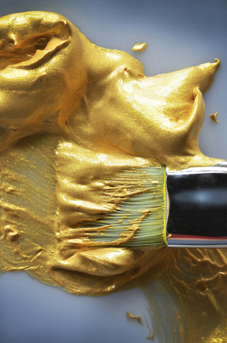 Nahaufnahme eines Pinsels mit goldener Farbe, Studioaufnahme