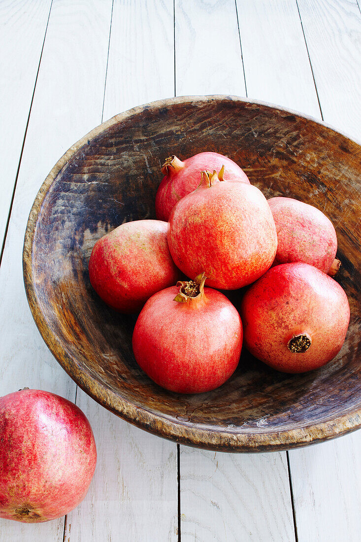 Pomegranats in wooden bowl, studio shot