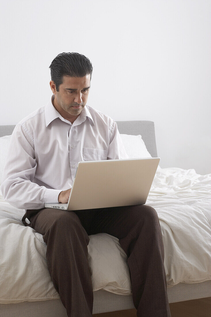 Man with Laptop on Bed