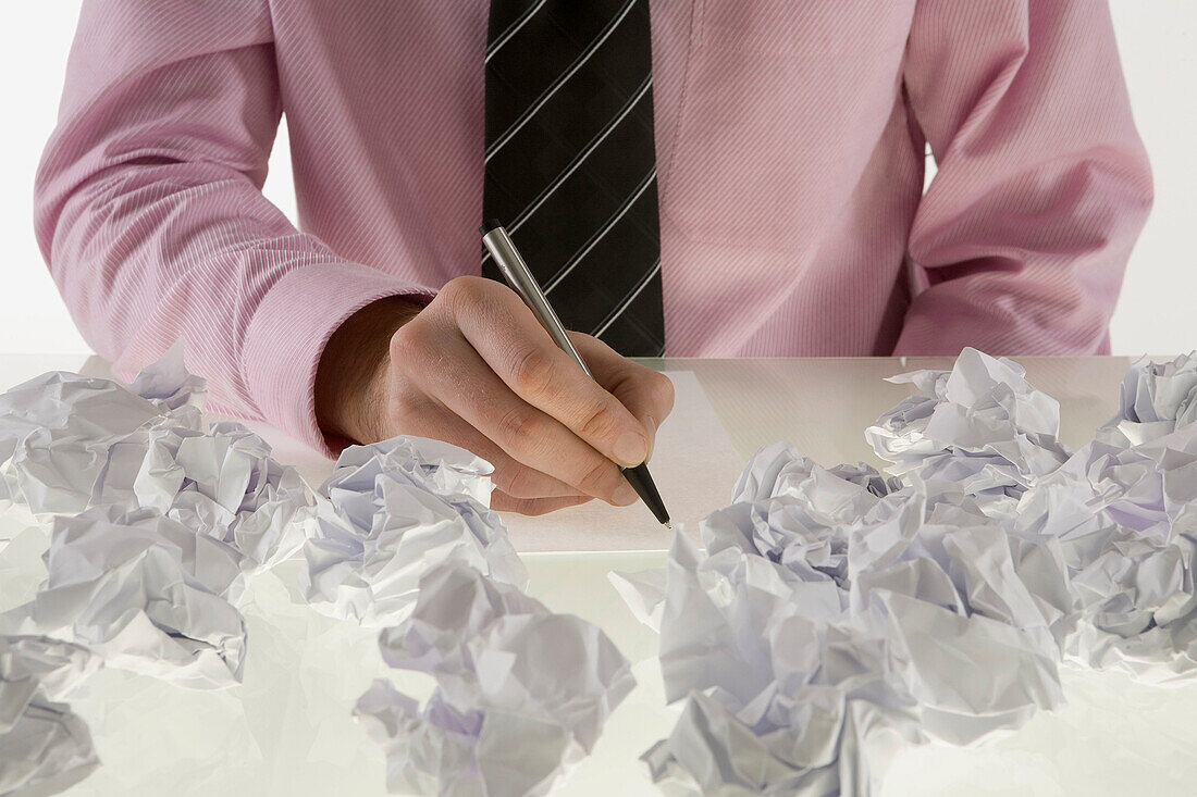 Businessman Surrounded by Crumpled Paper