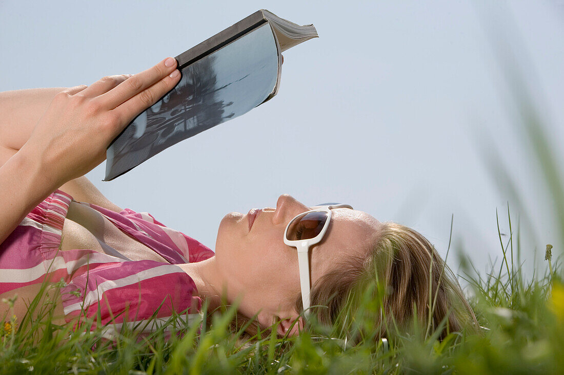 Frau liest Buch im Freien