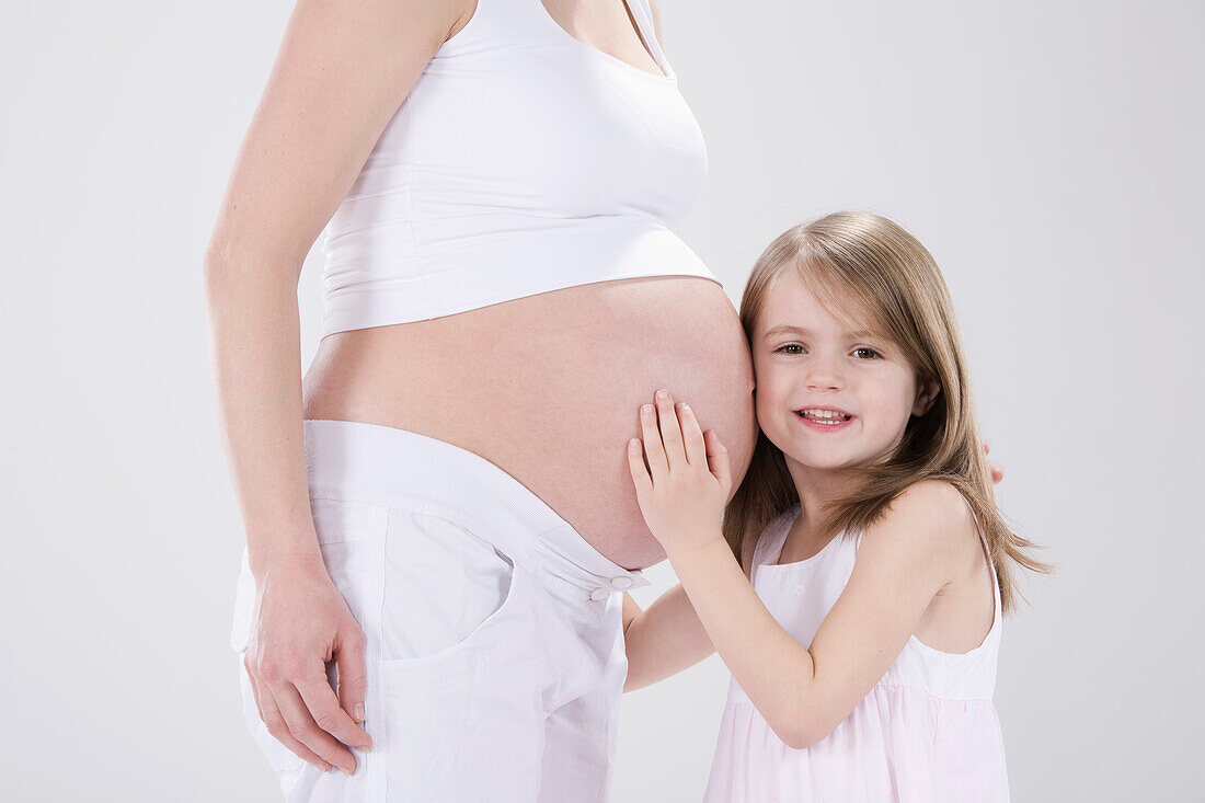 Little Girl Hugging Pregnant Mother