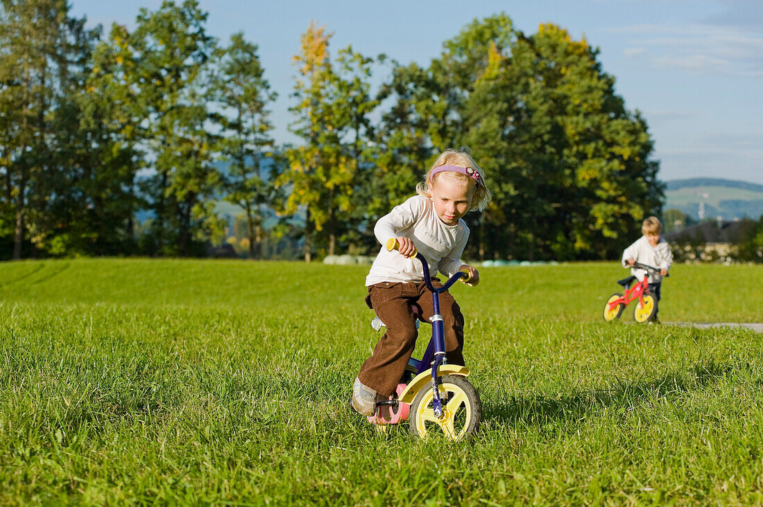 Boy and Girl Riding Bicycles, Salzburger Land, Austria