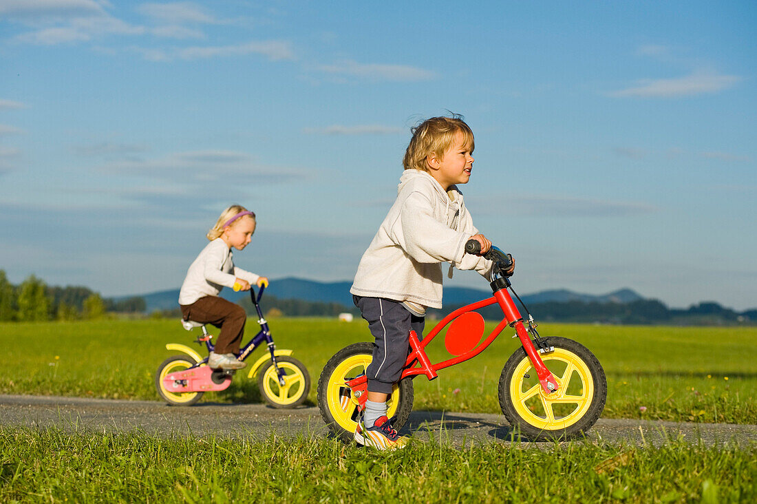 Junge und Mädchen auf Fahrrädern, Hof bei Salzburg, Salzburger Land, Österreich