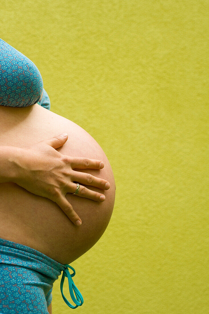 Profil des Bauches einer im neunten Monat schwangeren Frau