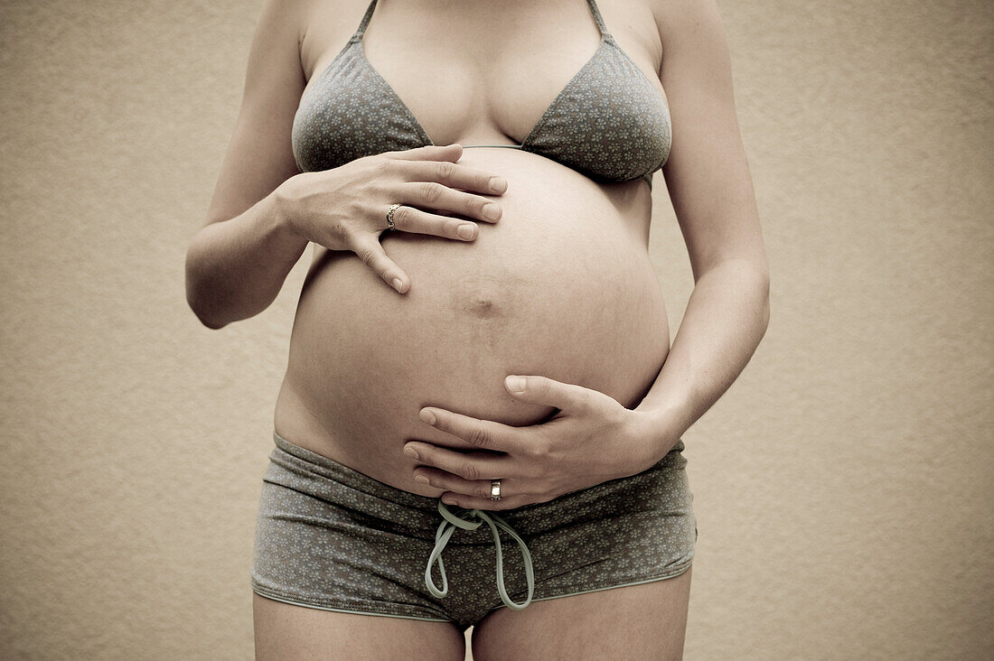 Woman, Nine Months Pregnant, Touching Her Belly