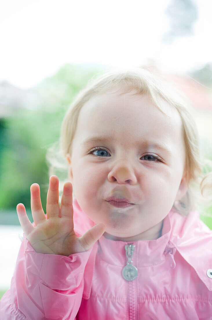 Little Girl Pressing Her Face Against the Window