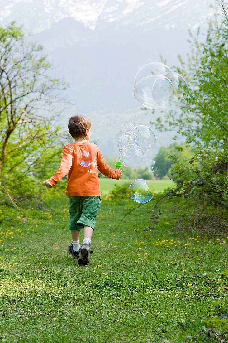 Boy Running and Blowing Bubbles, Salzburg, Austria