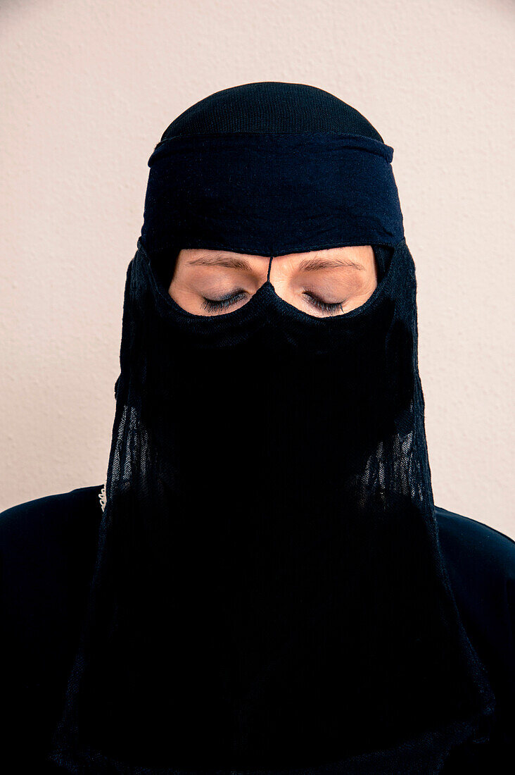Nahaufnahme einer Frau mit geschlossenen Augen, die einen schwarzen muslimischen Hidschab trägt, Studioaufnahme