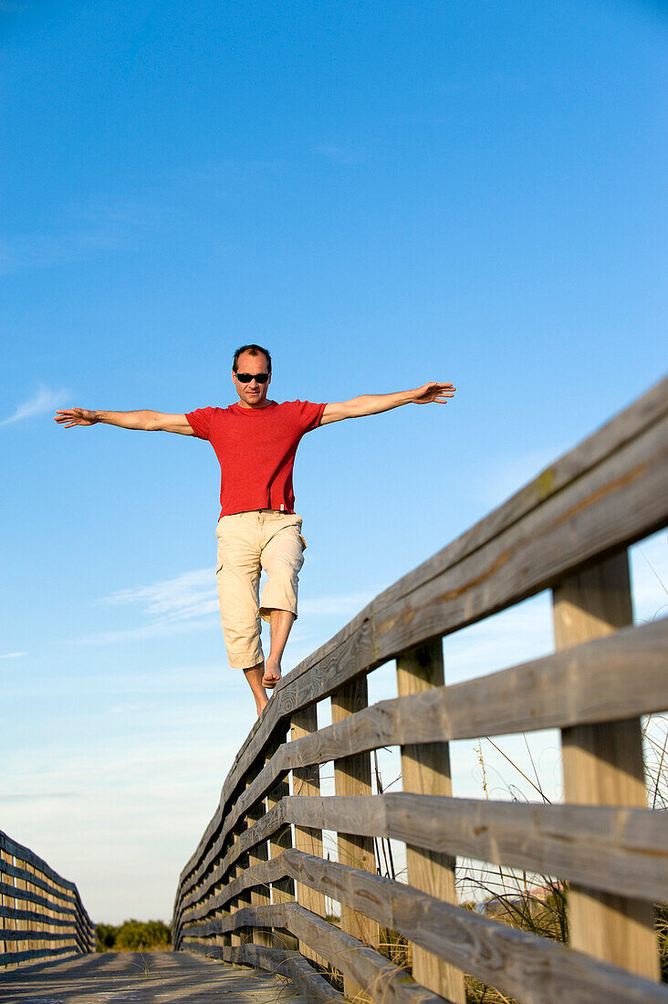 Man Balancing on Wooden Railing, Honeymoon Island, Florida, USA