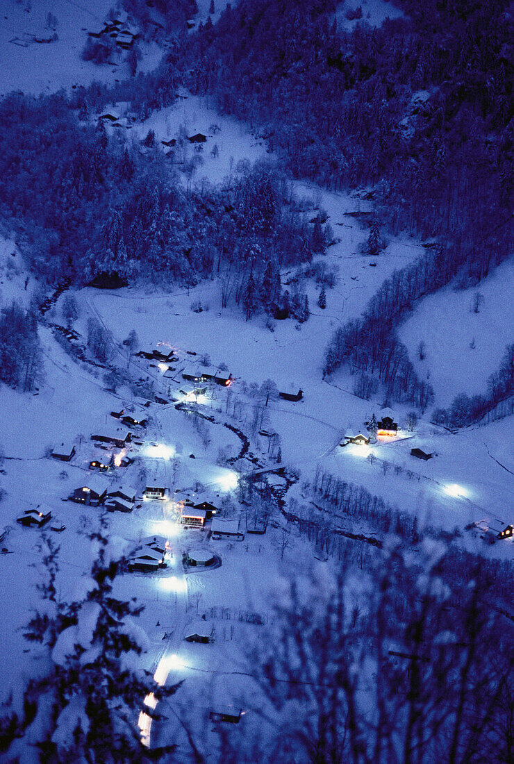 Overview of Houses and Trees from Mountain at Night in Winter, Switzerland