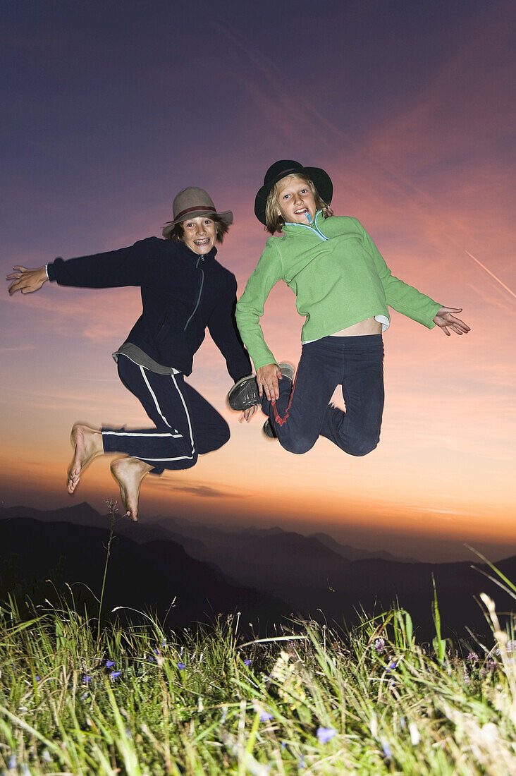 Mädchen und Junge springen in die Luft, Untersberg, Bayern, Deutschland