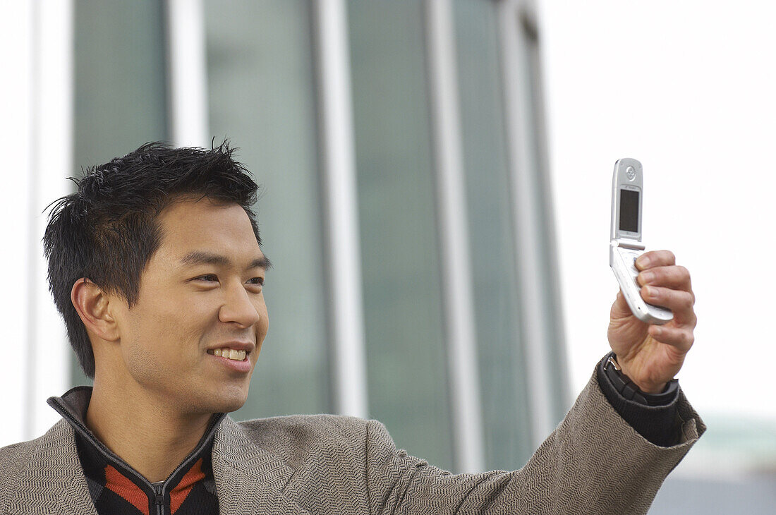 Man Taking Photo Of Himself With Cell Phone