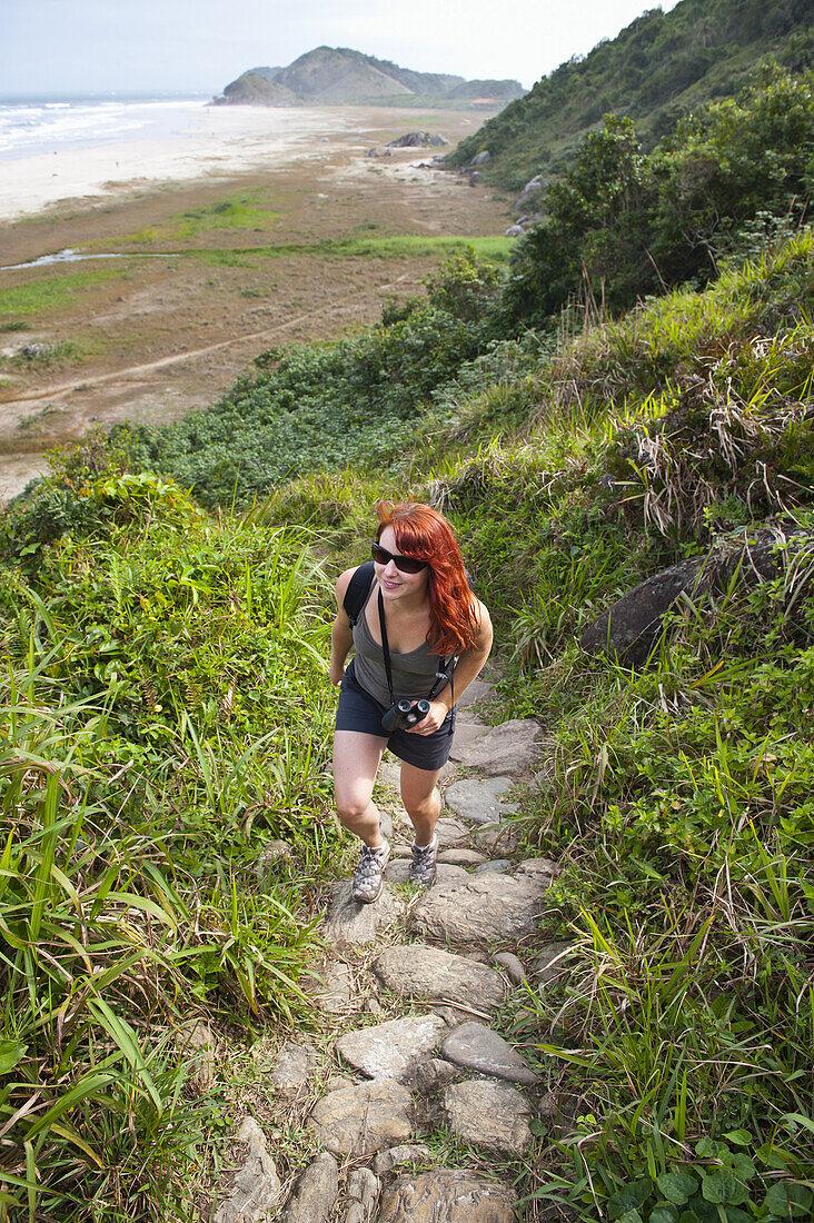 Frau beim Wandern auf den Küstenhügeln, Ilha do Mel, Parana, Brasilien