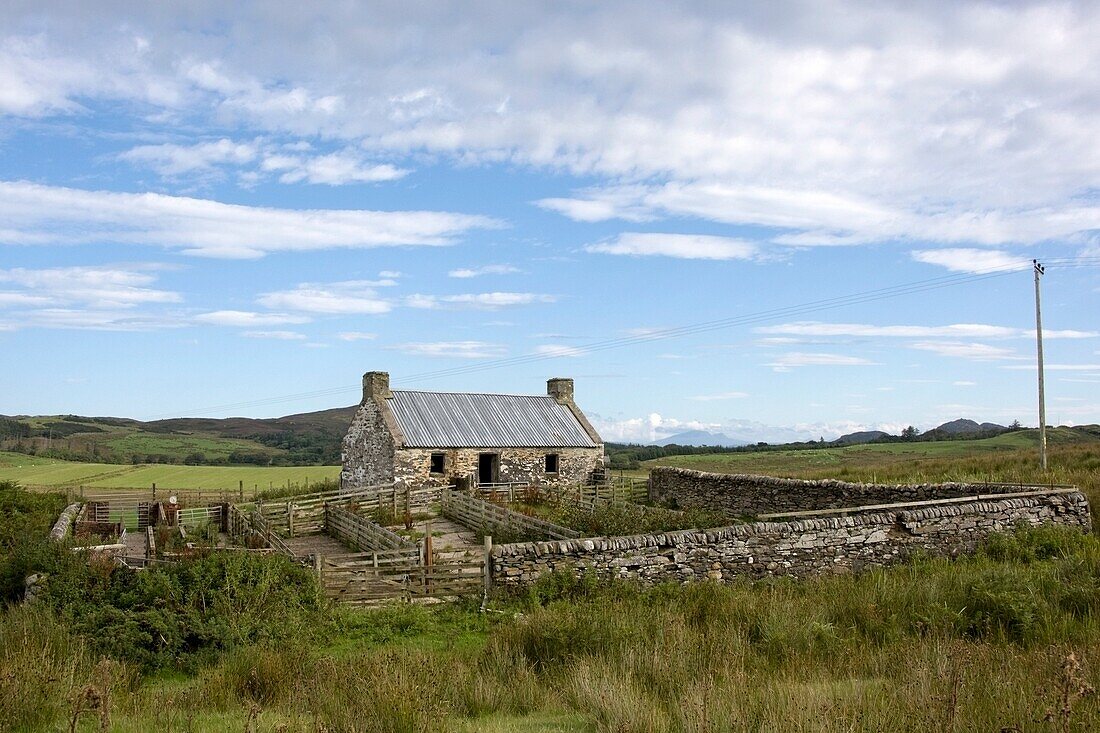 Isle of Colonsay, Schottland; Bauernhaus aus Stein, Zaun und umliegendes Feld