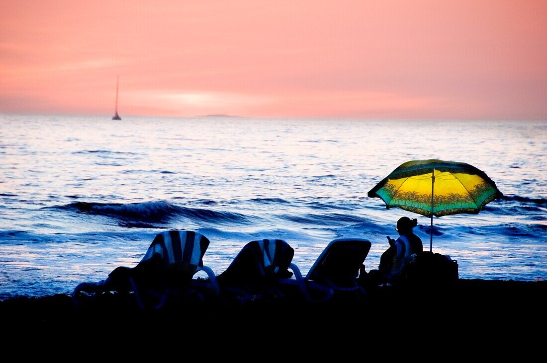 Silhouette von Strandstühlen bei Sonnenuntergang