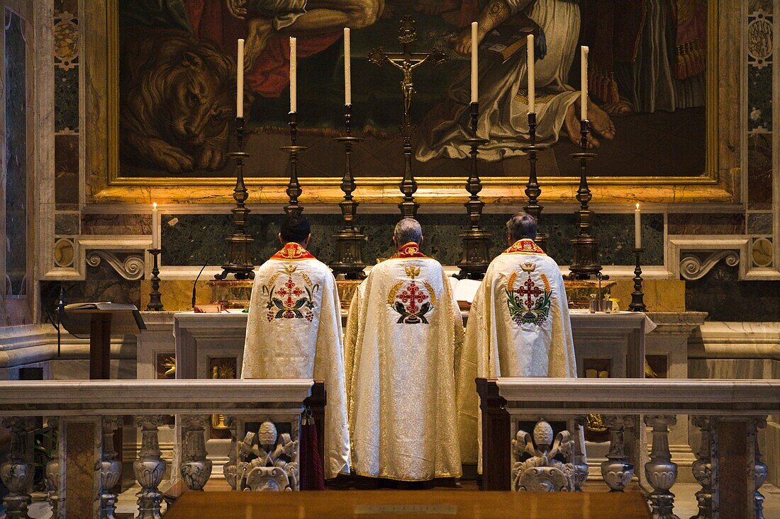 Drei Priester stehen am Altar im Petersdom; Vatikanstadt, Rom, Italien